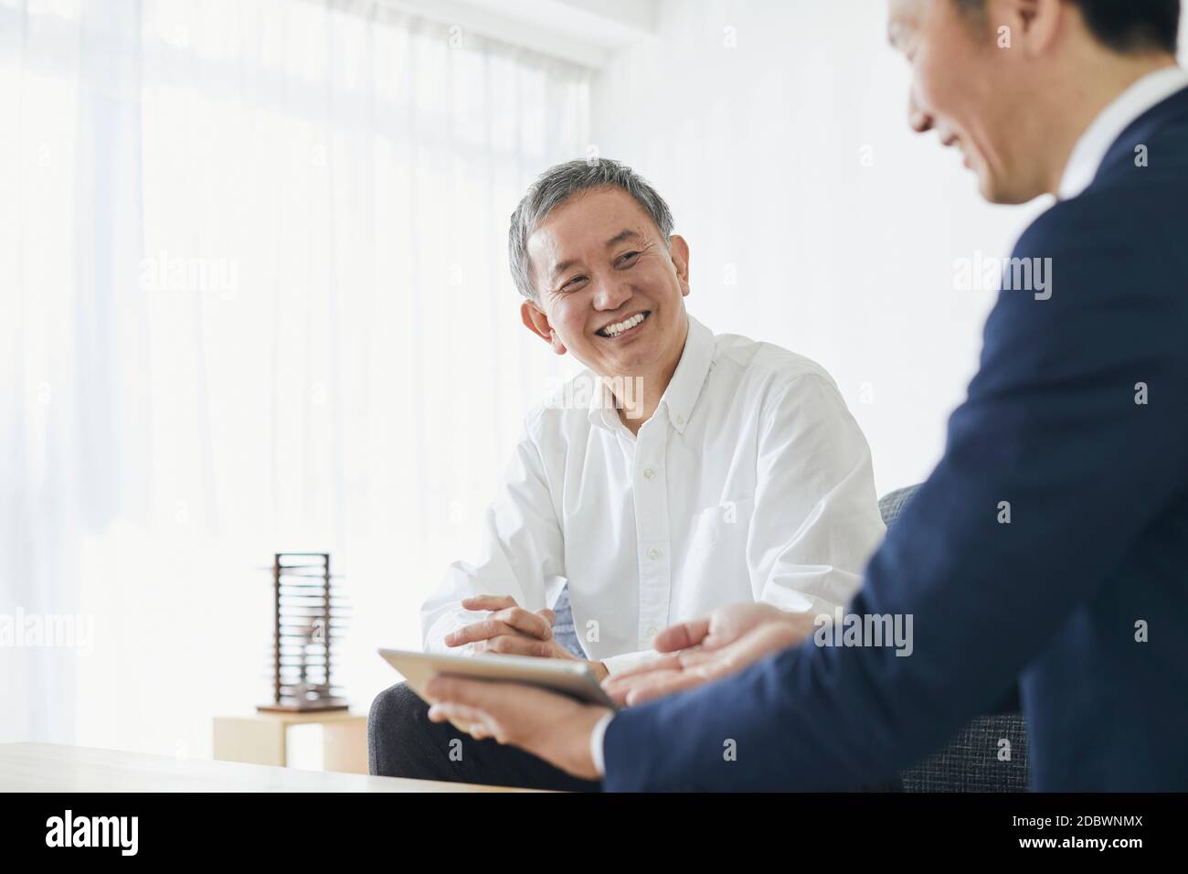Giapponese uomo di mezza età sorridente nella stanza Foto Stock