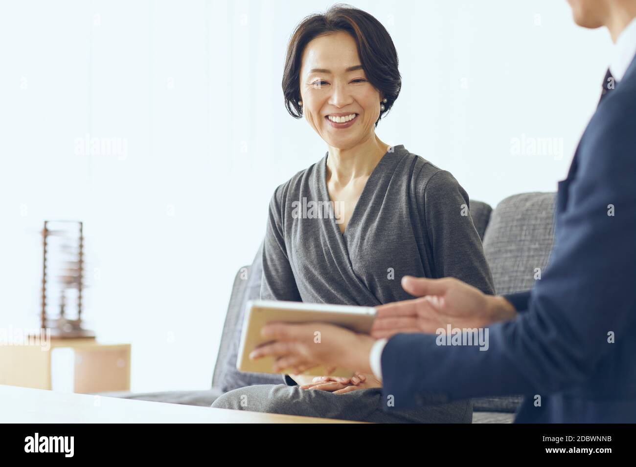 Donna giapponese di mezza età sorridente nella stanza Foto Stock
