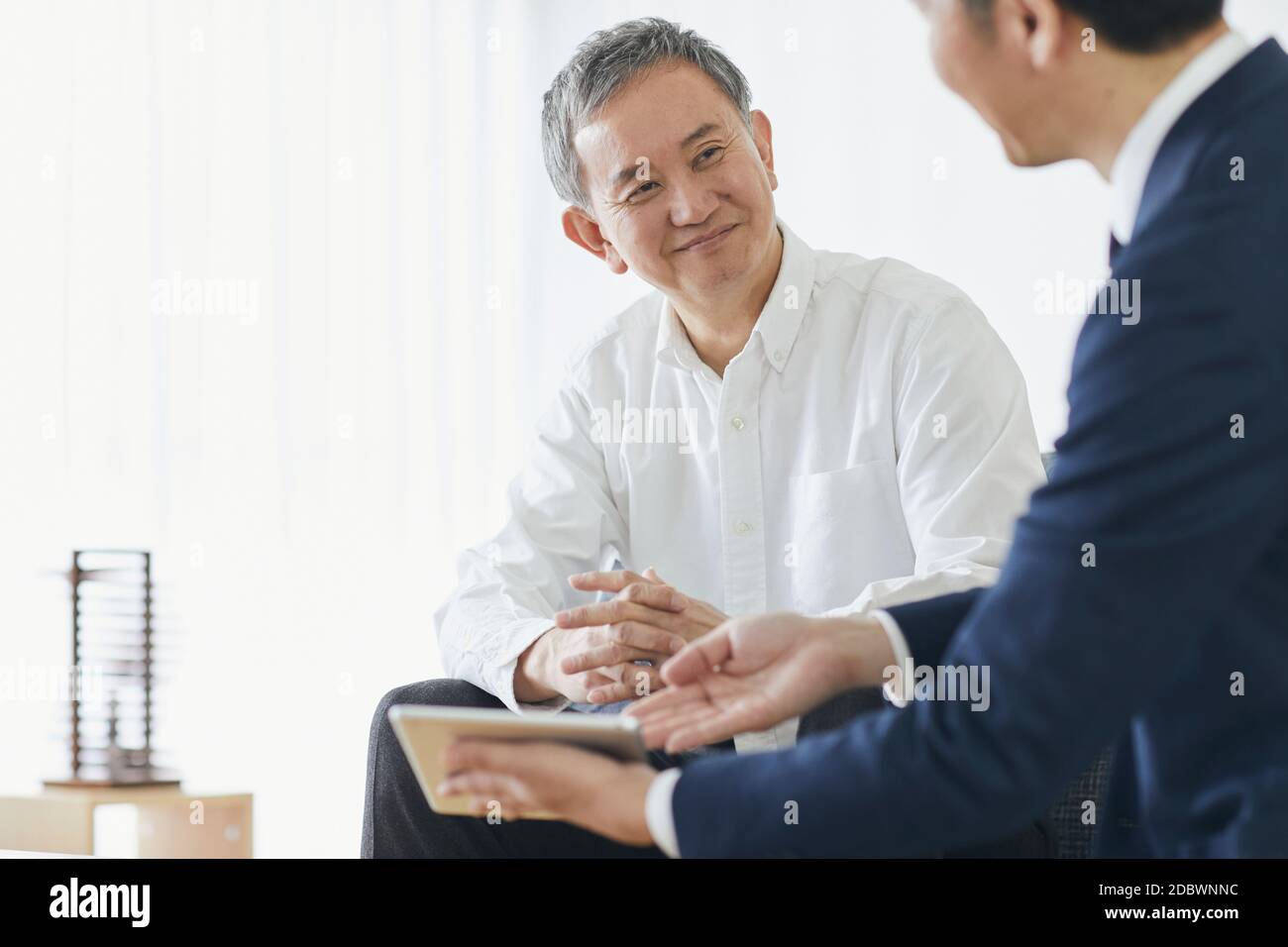 Giapponese uomo di mezza età sorridente nella stanza Foto Stock