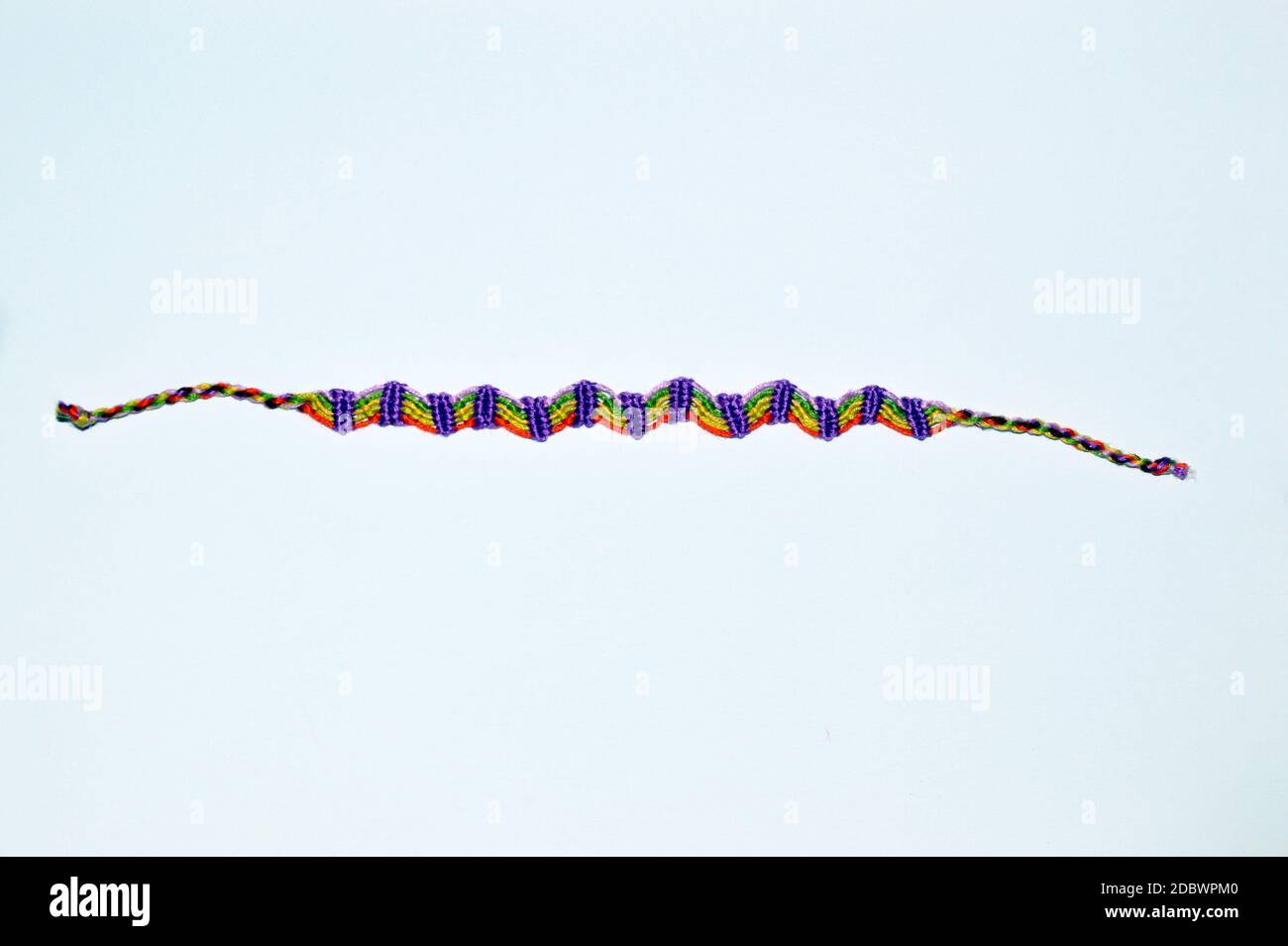 Braccialetto FY Friendship intrecciato realizzato a mano con filo lucido ricamato con nodi isolati su sfondo bianco. Foto Stock