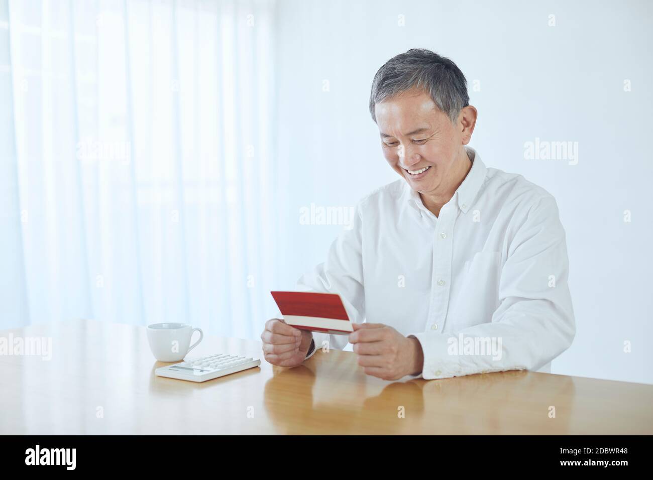 Giapponese uomo di mezza età sorridente nella stanza Foto Stock