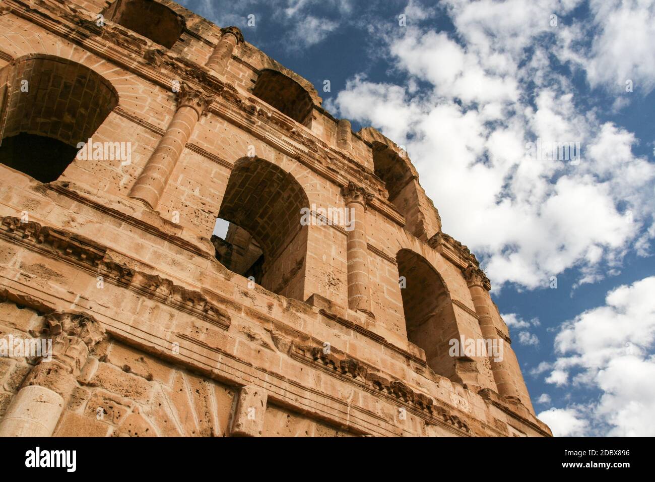 Vista su finestre ad arco di antiche El Jem colosseo (chiamato anche anfiteatro) con profondo cielo blu in background. El Djem, Tunisia Foto Stock