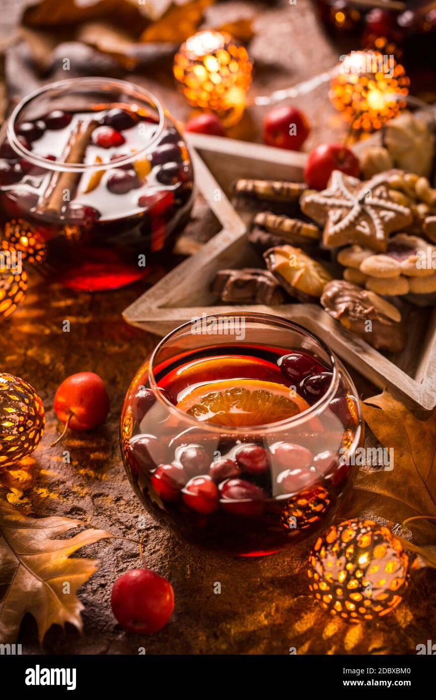 VIN brulé con arancia, mirtilli rossi, cannella, anice con biscotti, foglie d'autunno e luci natalizie Foto Stock