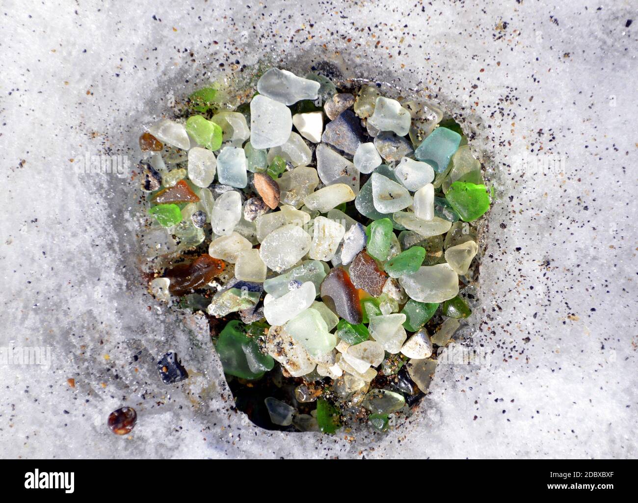 Vetro multicolore nel foro fatto di ghiaccio in un luogo unico 'Glass Beach' in Russia, mare giapponese. Foto Stock