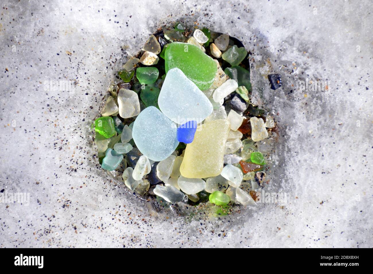 Vetro multicolore nel foro fatto di ghiaccio in un luogo unico 'Glass Beach' in Russia, mare giapponese. Foto Stock