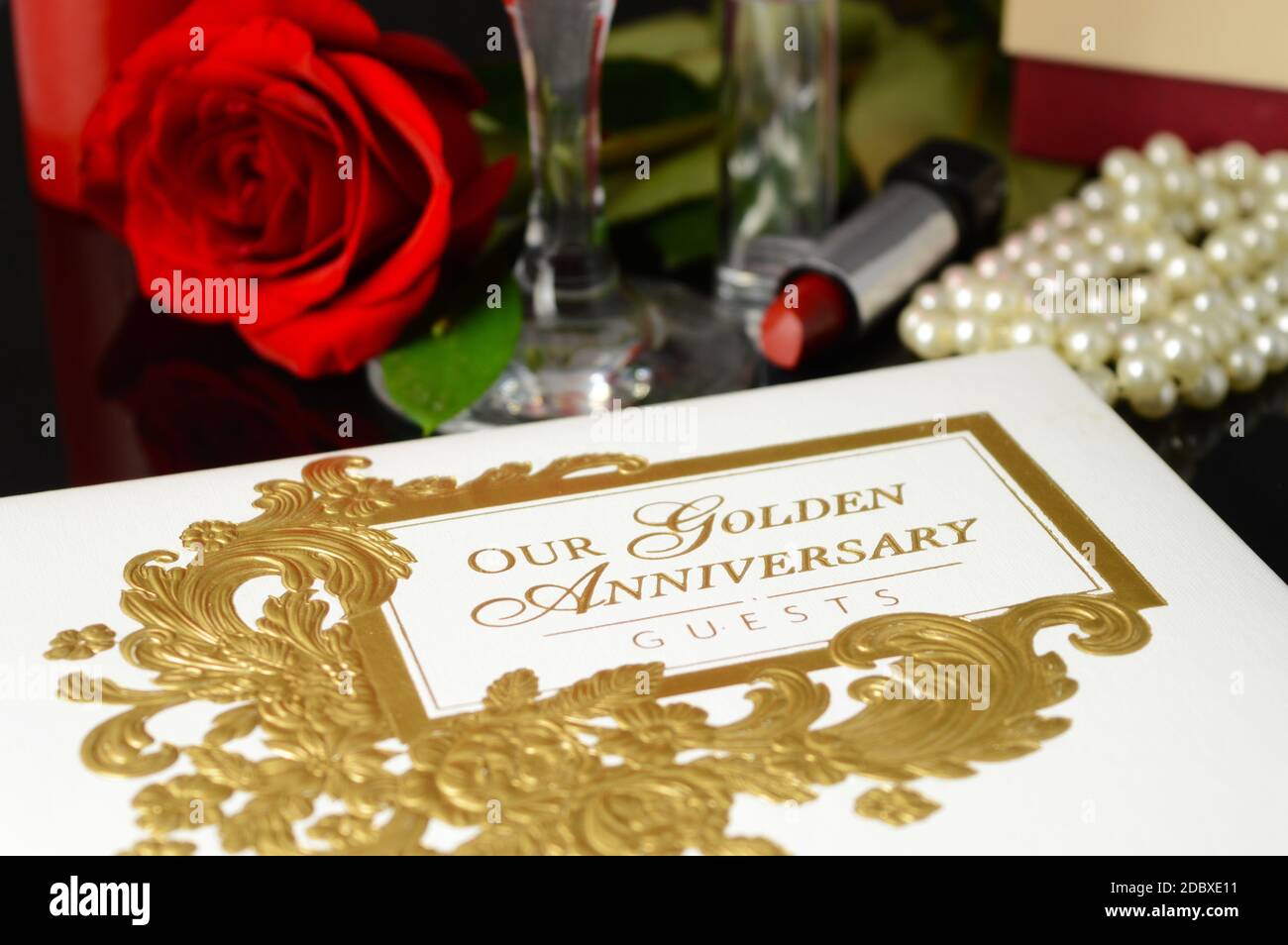 Un Libro degli ospiti dell'anniversario d'Oro accanto ad alcuni prodotti femminili. Foto Stock