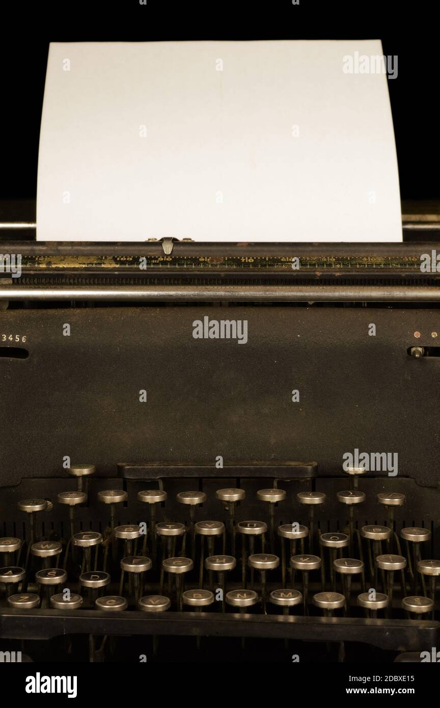 Una vista in primo piano di un'antica macchina da scrivere della metà del 1900 con un pezzo di carta in bianco. Foto Stock