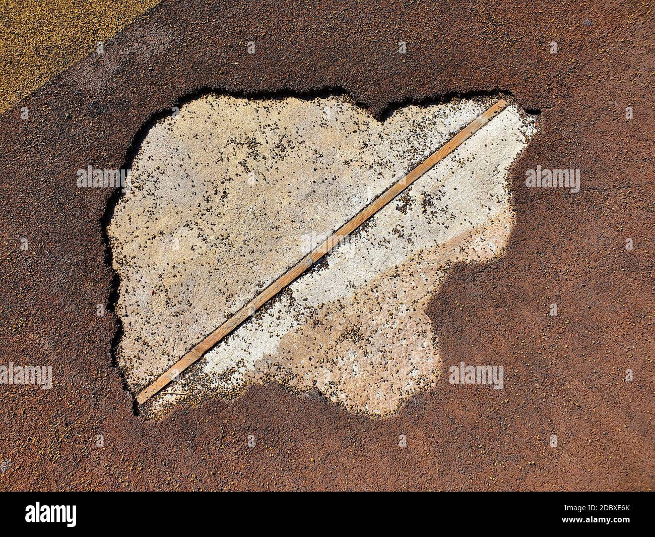 Rivestimento di gomma marrone danneggiato del parco giochi. Vecchio tessuto sportivo, vista dall'alto. Foto Stock