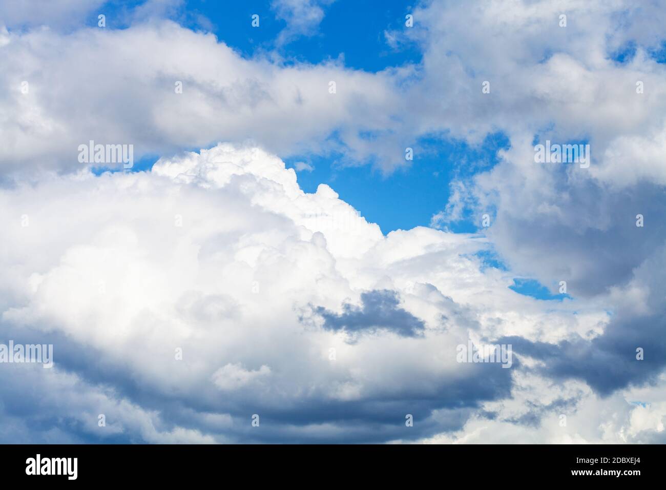 grandi nuvole bianche e grigie nel cielo blu sul sole giorno d'estate Foto Stock