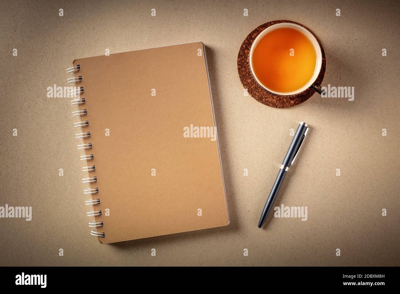 Un diario su una scrivania, girato dall'alto con una penna e una tazza di tè su uno sfondo rustico Foto Stock