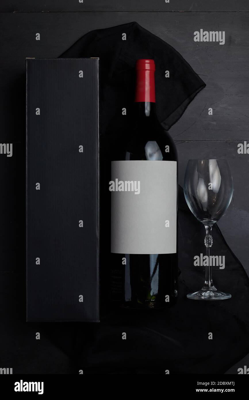 Una bottiglia di vino su un tavolo di legno nero da vista dall'alto con tappo rosso Foto Stock