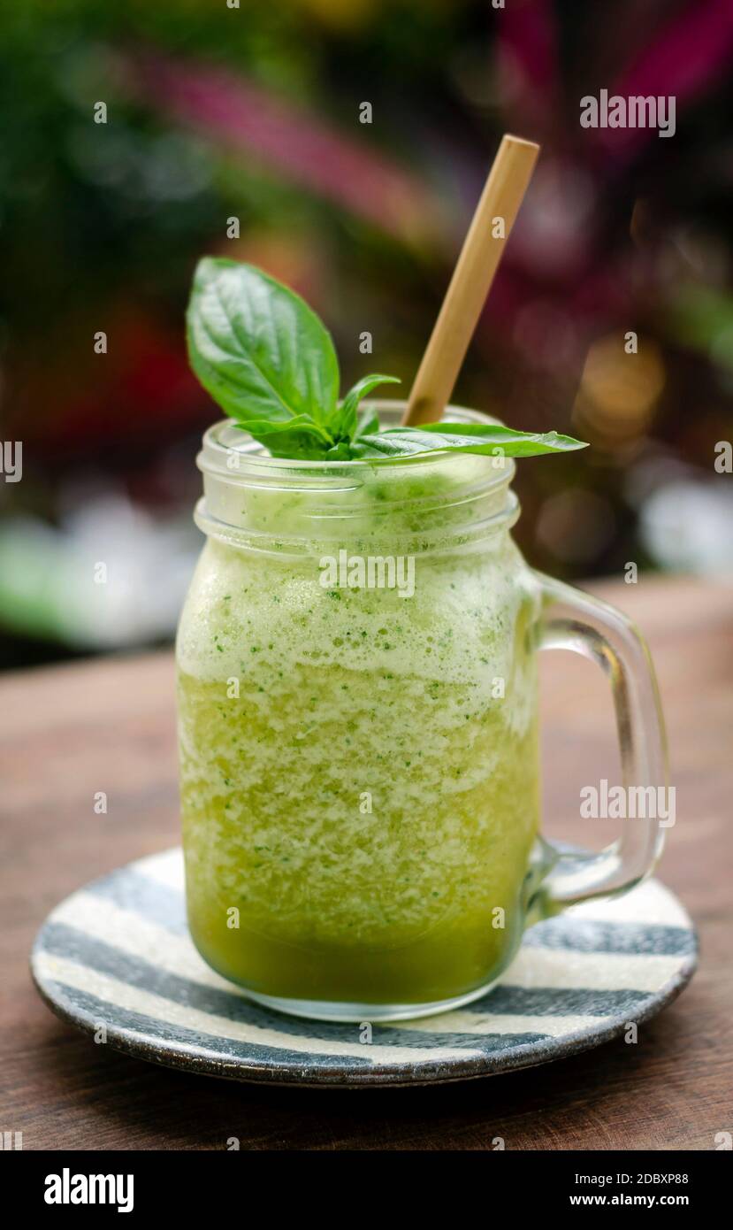 kiwi di ananas organico e frutta di basilico detox bevanda sana del frullato all'aperto in vetro Foto Stock