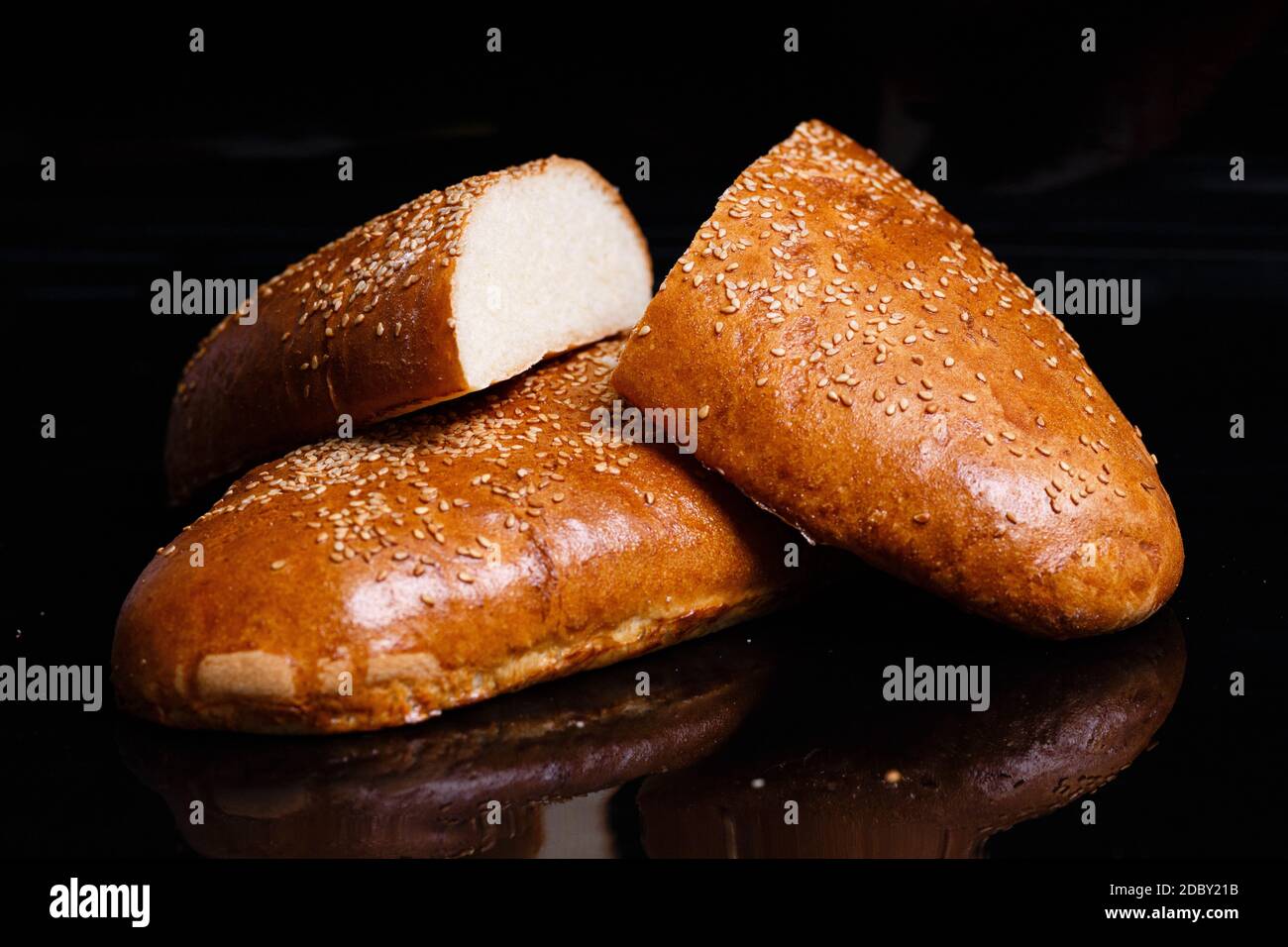 Dolci fatti in casa. Pane bianco croccante tagliato con un coltello. Foto su sfondo nero. Foto Stock