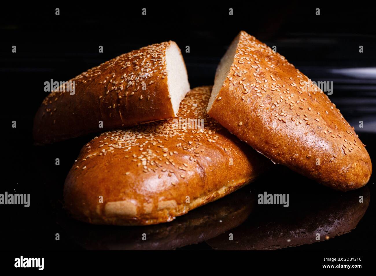 Dolci fatti in casa. Pane bianco croccante tagliato con un coltello. Foto su sfondo nero. Foto Stock