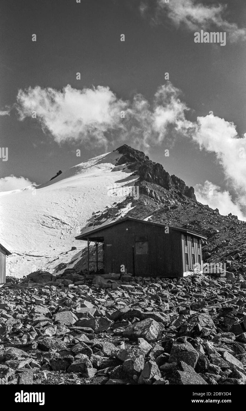 Kenya. Si tratta di alpinismo sul Monte Kenya la montagna più alta del Kenya a 17 metri; 5199m come era nel 1976/77 guardando verso il ghiacciaio di Lewis e la vetta satellite di Point Lenana con l'Associazione Alpina austriaca ha finanziato Arthur Firmin Top Hut in memoria di uno dei migliori alpinisti del Kenya. Punto Lenana a 16,355 piedi; 4985m è la terza cima più alta della montagna che è il punto più alto che la maggior parte della gente può raggiungere sul Monte Kenya senza abilità di alpinismo puka Foto Stock