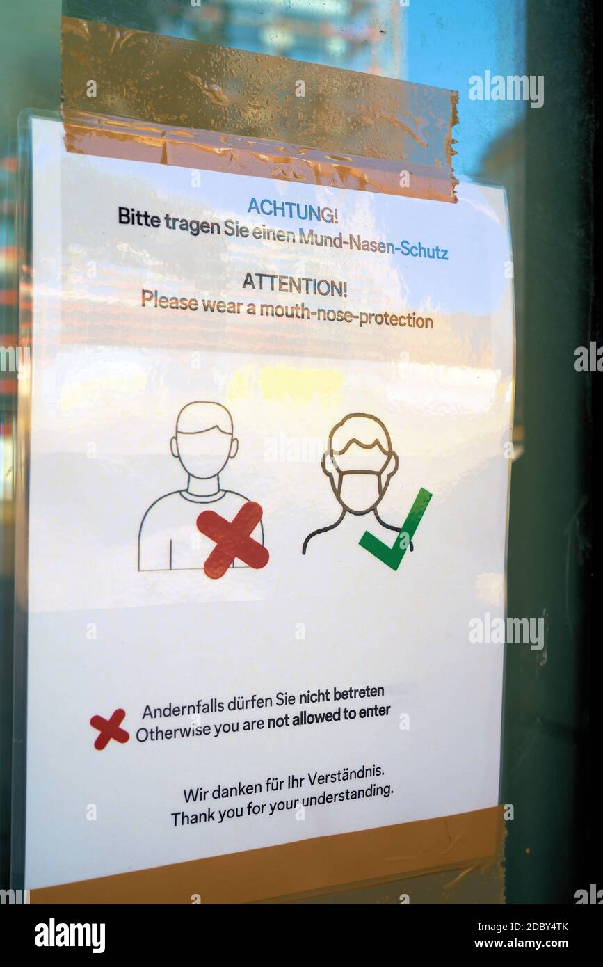 Richiesta di indossare una protezione per bocca e naso sul Ingresso a un negozio in Germania durante la pandemia di Corona Foto Stock