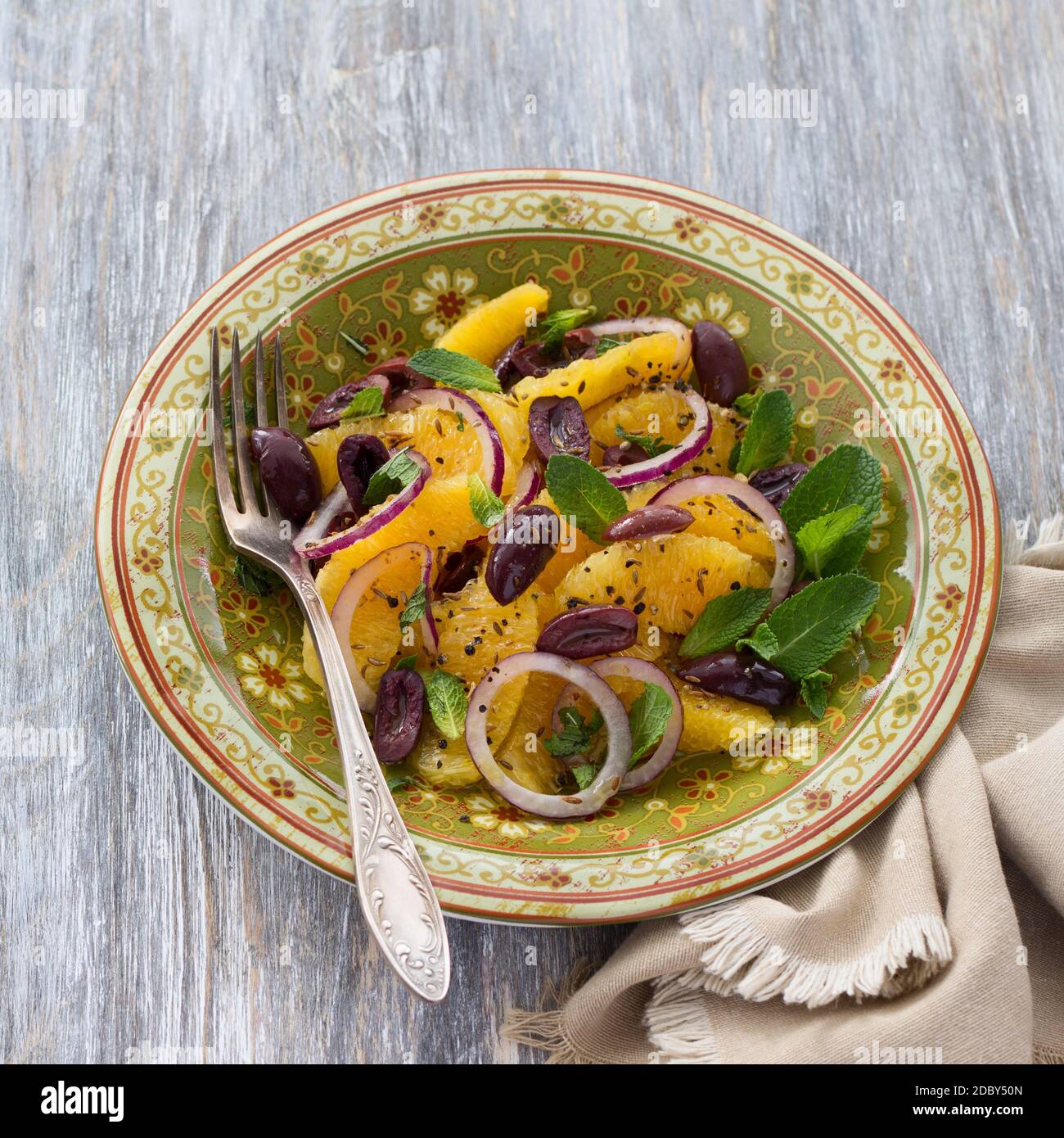 Insalata marocchina di arance con cipolle rosse, olive e zira su un tavolo di legno Foto Stock