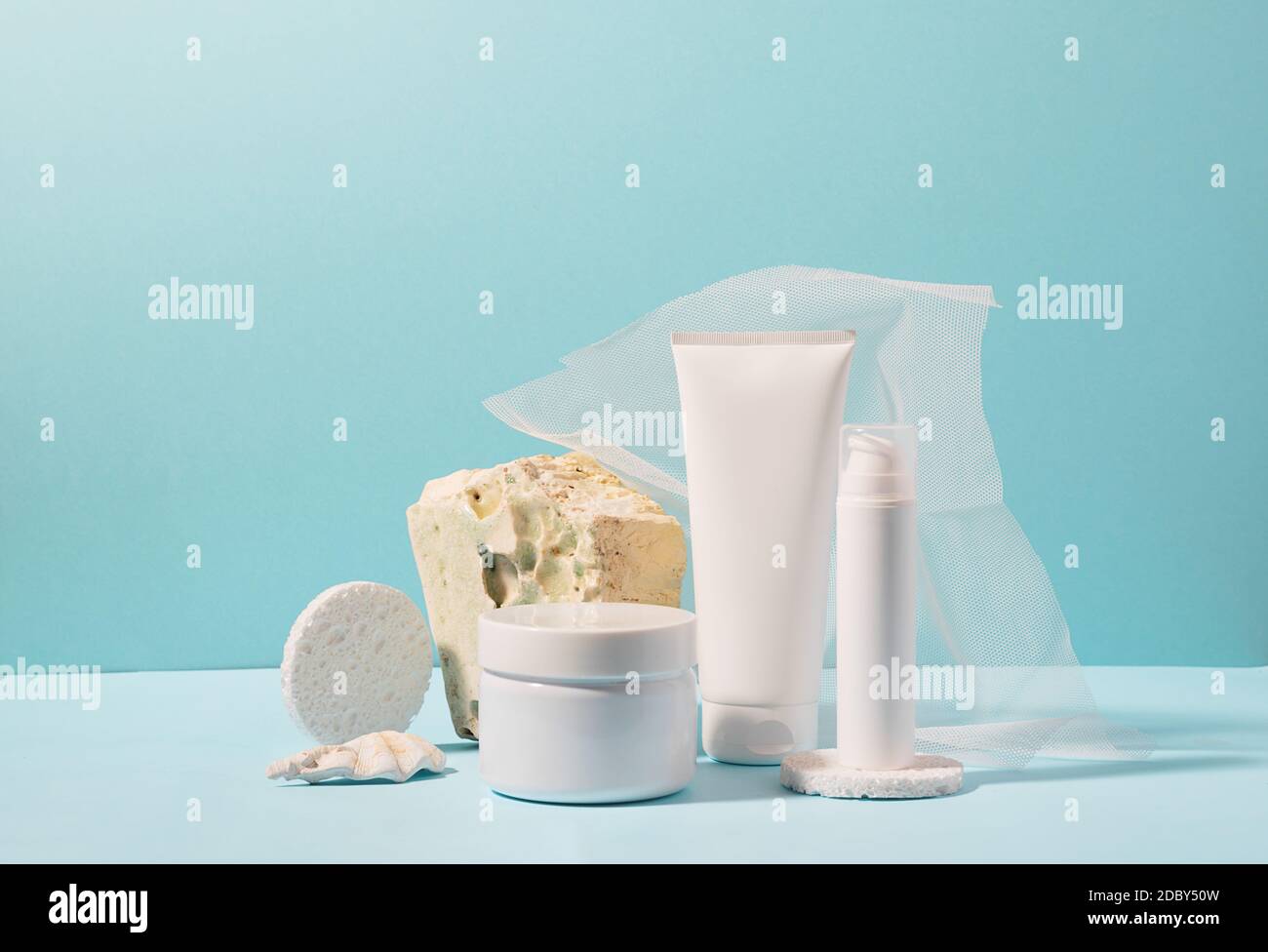 Gruppo di bottiglie cosmetiche su un moderno podio astratto sfondo blu Foto Stock