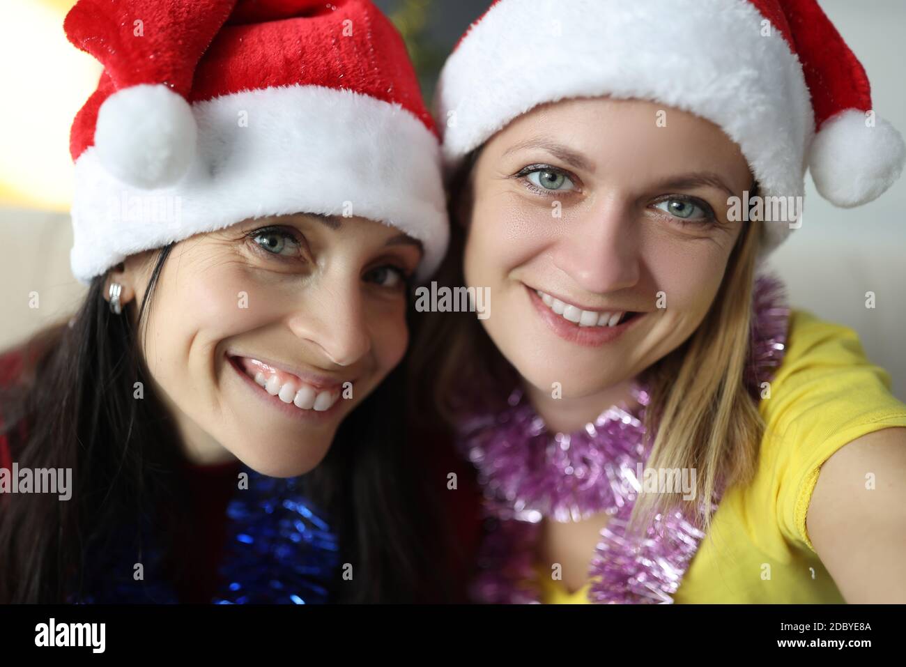 Ritratto di due donne nei cappelli di babbo natale decorazioni a casa Foto Stock