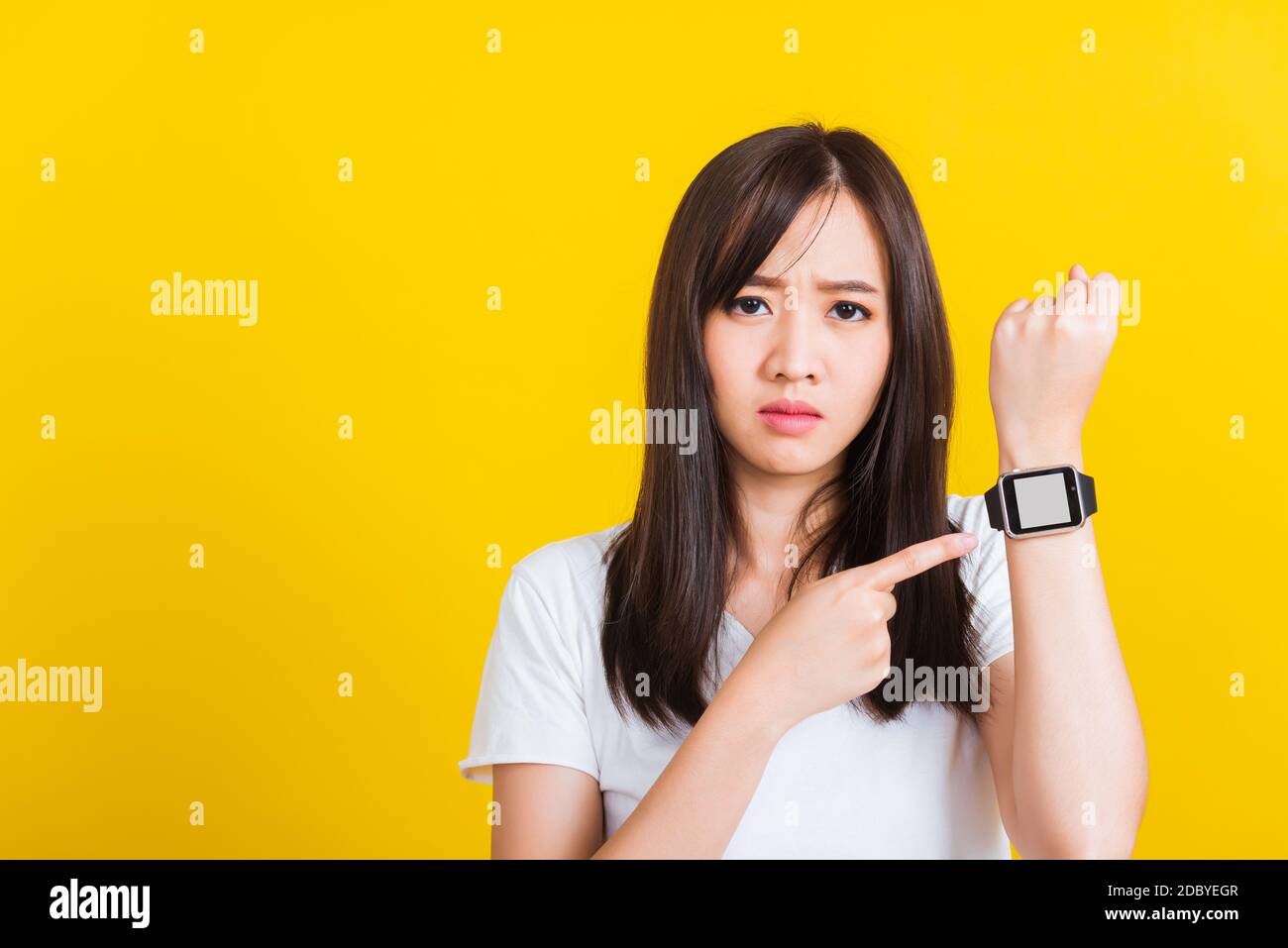 Siete in ritardo non in tempo, Ritratto asiatico di una bella donna felice giovane paura ragazza casual mostrando e puntando dito il suo studio orologio da polso è stato girato Foto Stock
