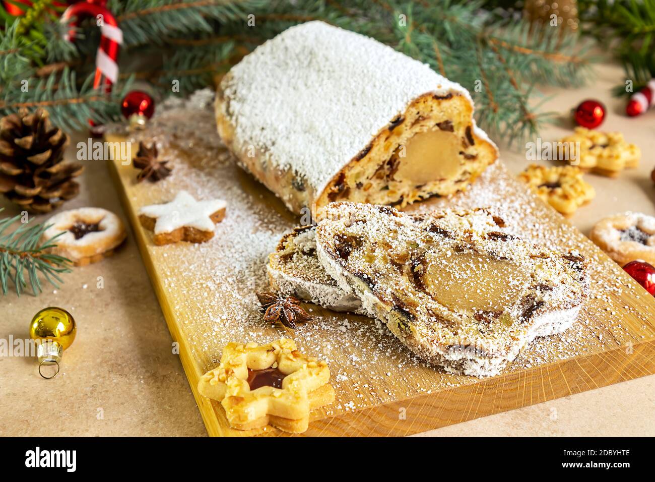 Stollen con marzapane. Tradizionale torta di Natale tedesca o pane di frutta con decorazioni natalizie. Foto Stock
