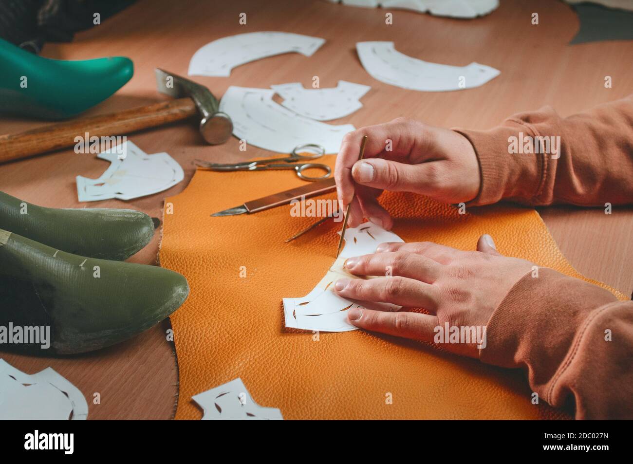 Calzolaio che fa i modelli dal cuoio giallo sul tavolo Foto Stock