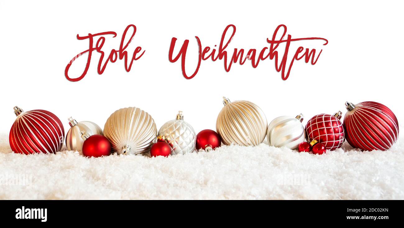 Calligrafia tedesca Frohe Weihnachten significa buon Natale su isolato sfondo bianco. Rosso e bianco Natale Ball ornamento sulla neve. Foto Stock