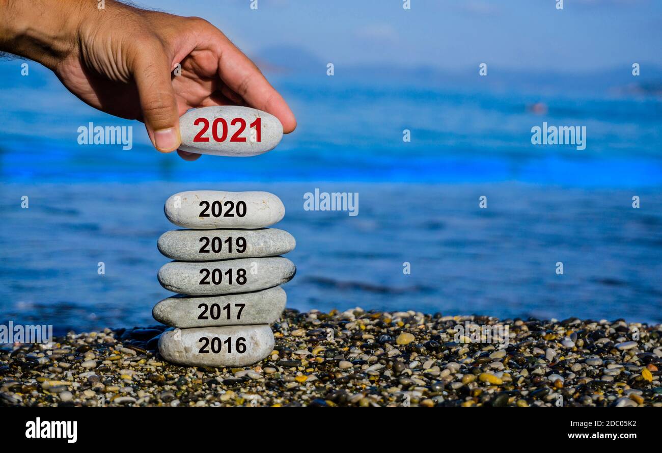 Il nuovo anno 2021 sta per arrivare. Il vecchio anno 2020 passa allo sfondo del 2021. Svolta positiva del vecchio anno. Felice anno nuovo 2021 sostituire 2020. Foto Stock