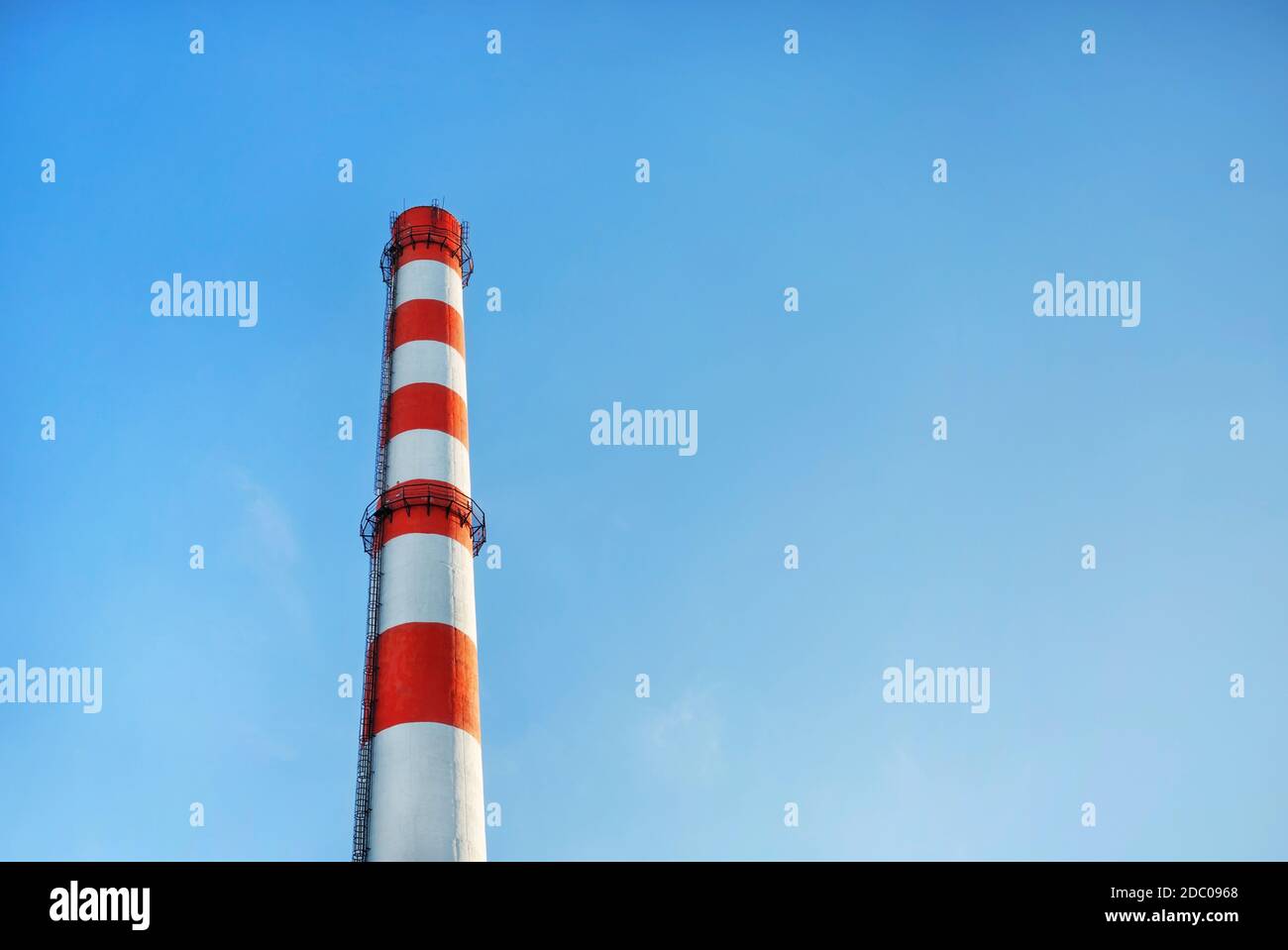 Camino di fabbrica con strisce rosse e bianche su sfondo blu cielo. Foto Stock