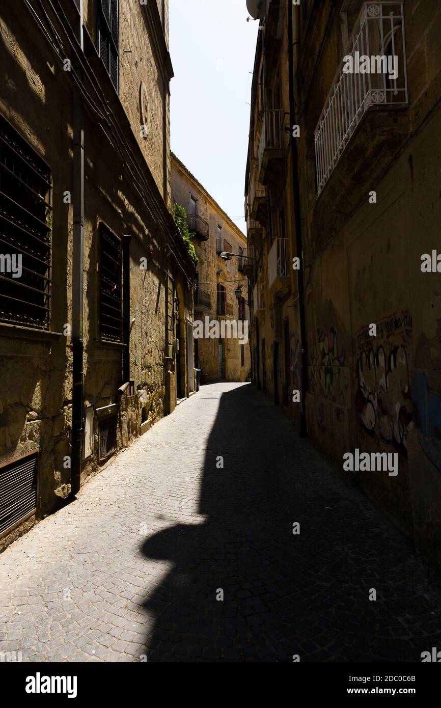Sicilia, Italia. Strada stretta tra vecchi edifici nel centro storico di Enna. Foto Stock