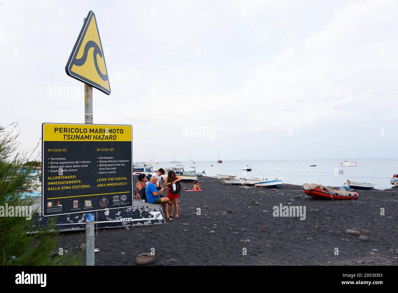Sicilia, Italia. Un cartello di avvertimento sulla spiaggia sull'isola vulcanica di Stromboli fornisce istruzioni in caso di un evento geologico importante. Foto Stock