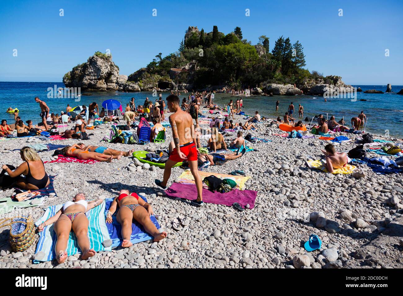 Sicilia, Italia. I turisti affollano la spiaggia Isola Bella in una calda giornata di sole. Foto Stock