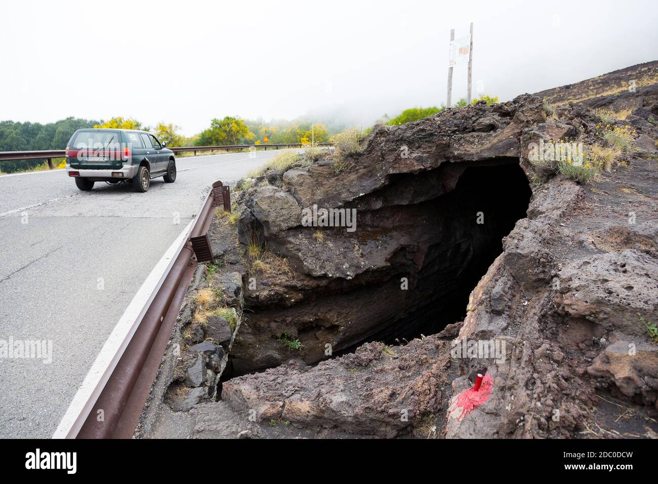 Sicilia, Italia. Un veicolo a quattro ruote motrici passa davanti all'ingresso della Grotta dei tre Livelli, una grotta lavica facilmente accessibile Foto Stock