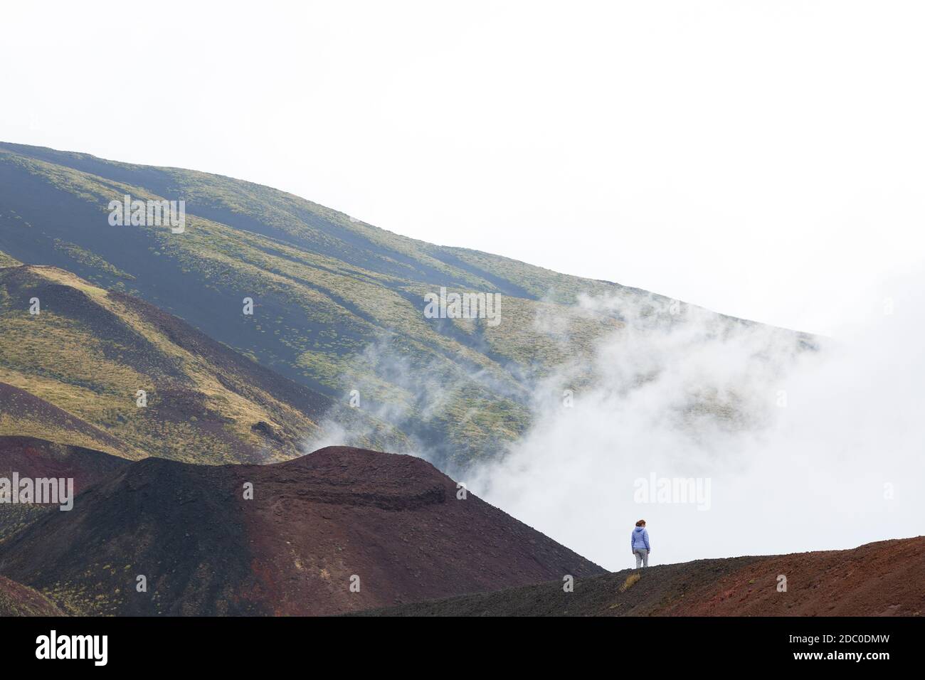 Sicilia, Italia. Una sola donna turistica esplora il bordo del cratere Silvestri superiore. Foto Stock
