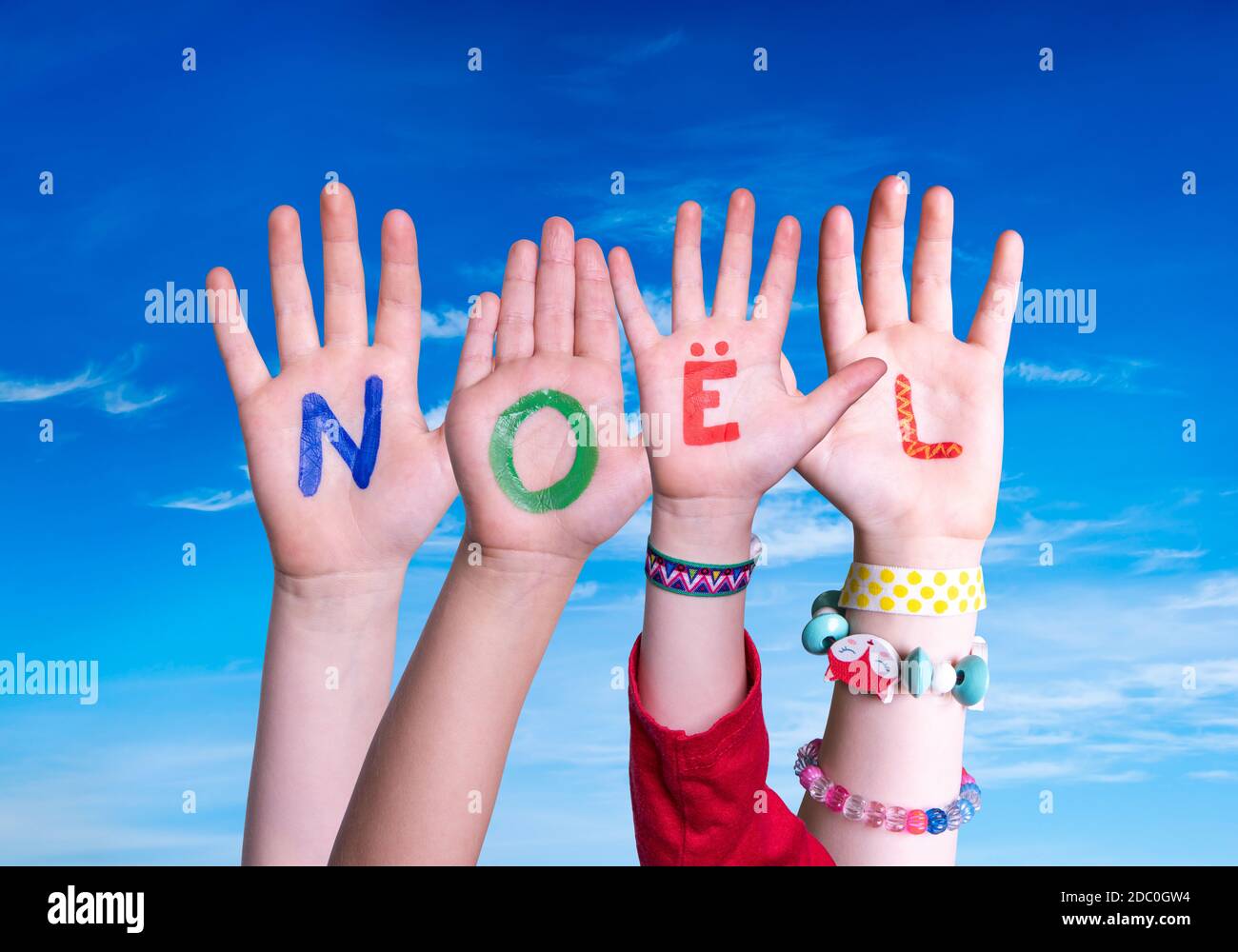 Bambini mani costruire colorato francese parola Noel significa Natale. Cielo blu come sfondo Foto Stock