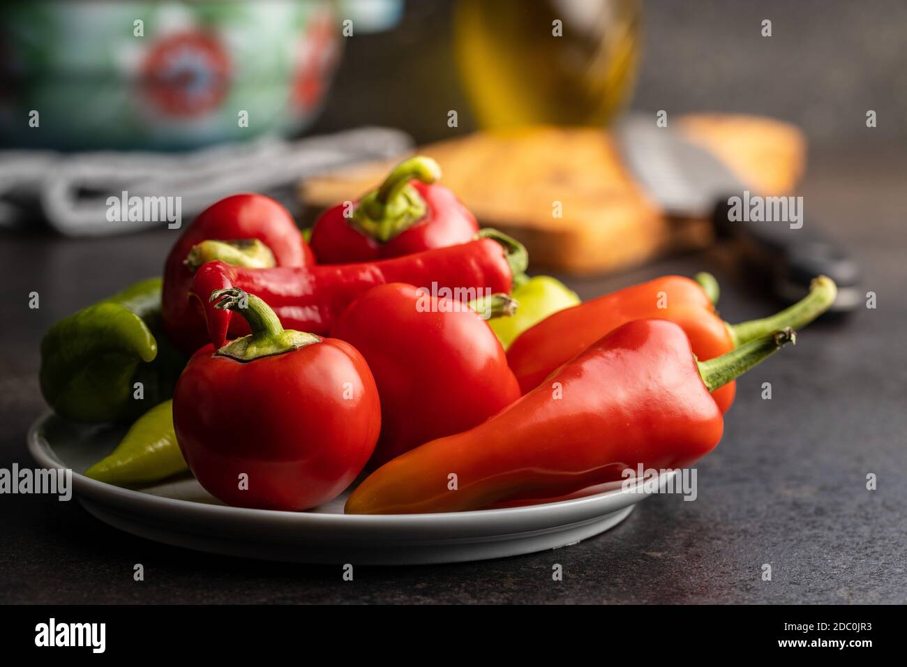 Vari tipi di peperoni vegetali su tavola nera. Foto Stock