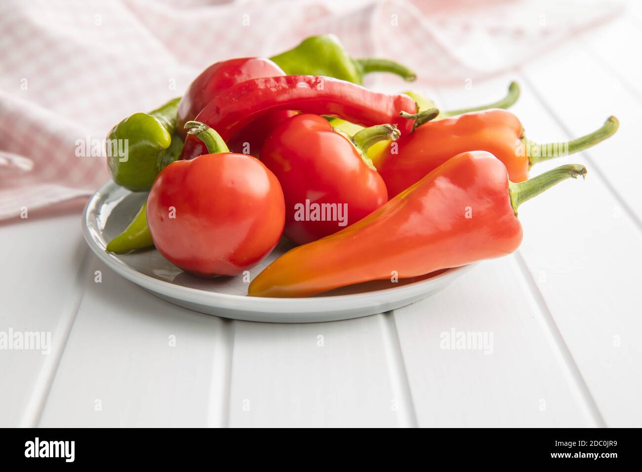 Vari tipi di peperoni vegetali su tavola bianca. Foto Stock