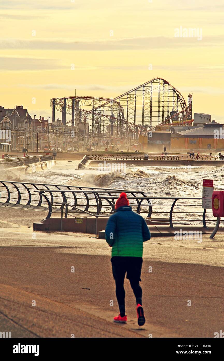 Solitario jogger di fronte al mare Rough in inverno a. Blackpool Foto Stock
