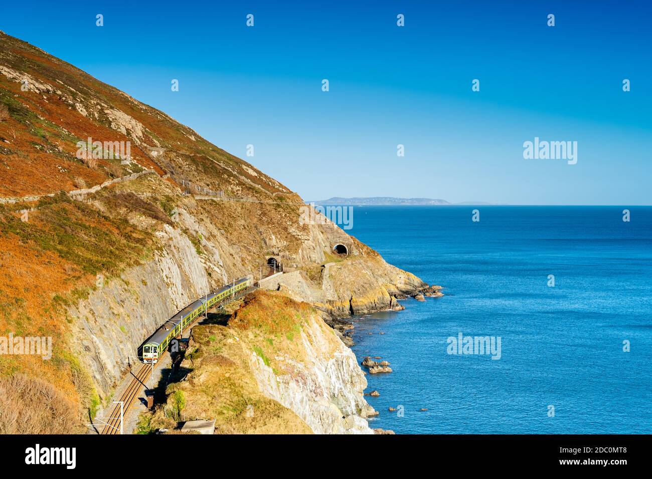 Treno di uscire dal tunnel. Vista dalla scogliera a piedi Bray a Greystones con la splendida costa e scogliere e mare, Irlanda Foto Stock