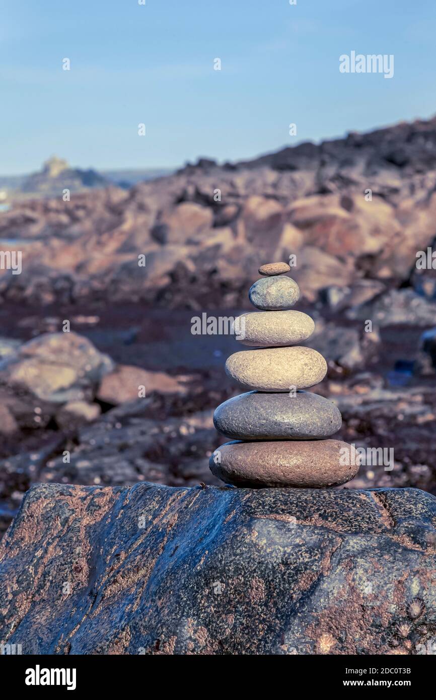 Carino in pietra bilanciato su alcune rocce lungo la costa della Cornovaglia, perfetto per un biglietto d'auguri, una borsa regalo o un'immagine del calendario Foto Stock