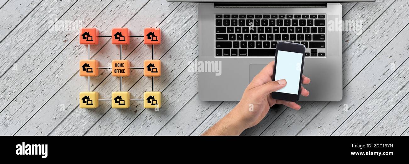 Cube griglia con message HOME OFFICE e consegnare un computer su sfondo di legno Foto Stock