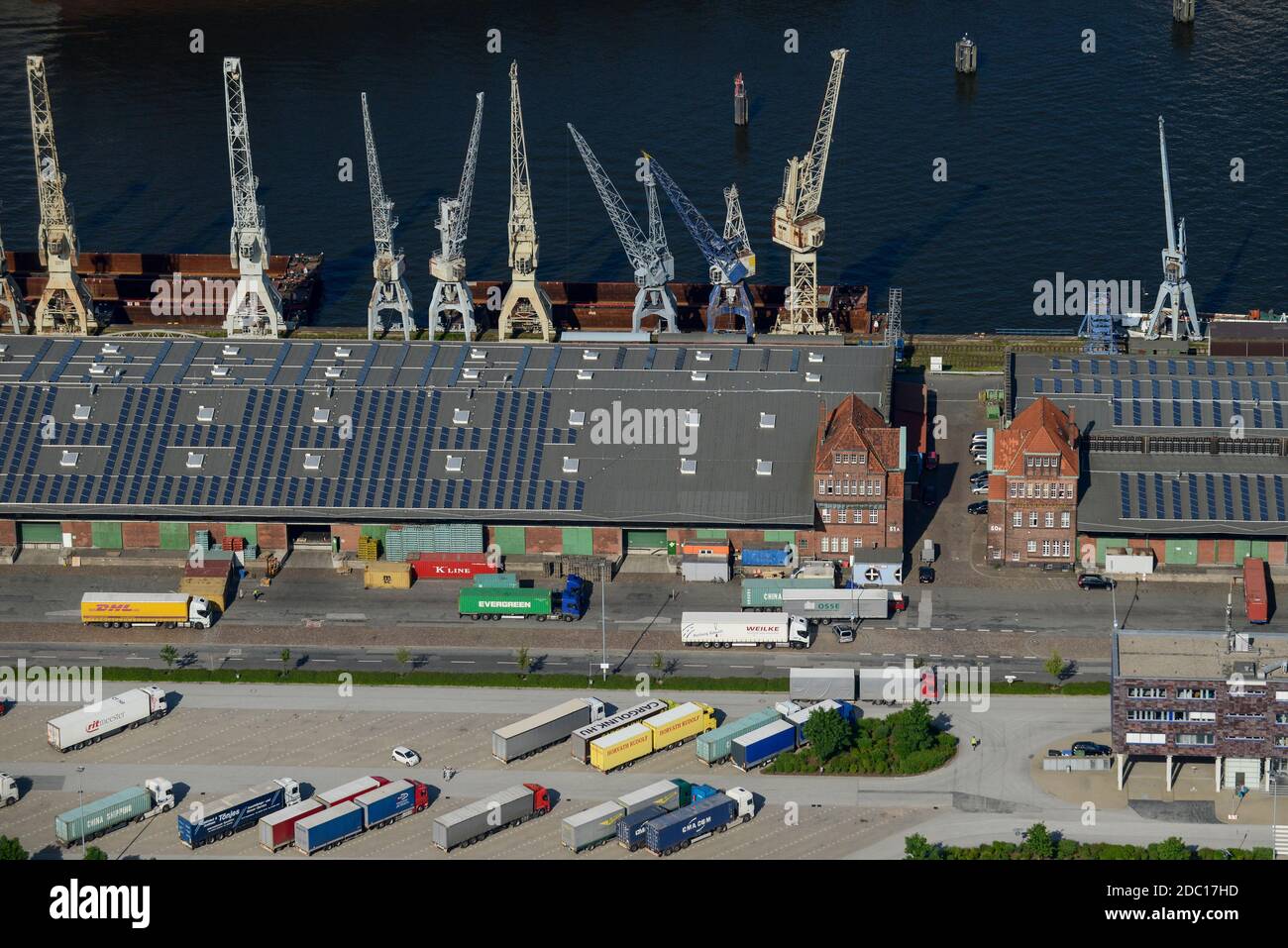 GERMANIA Amburgo, pannello fotovoltaico della società Amburgo energia sul tetto del deposito portuale edificio n. 50-52, parcheggio camion presso la Wharf store house / DEUTSCHLAND Hamburgs groesste Photovoltaik Anlage auf dem Kaischuppen 50-52 im Hamburger Hafen, Betreiber ist der staedtische Energieversorger Hamburg Energie, Die 30.000 Quadratmetro Dachflaeche werden von Stiftung Hamburg Maritim gepachtet Foto Stock