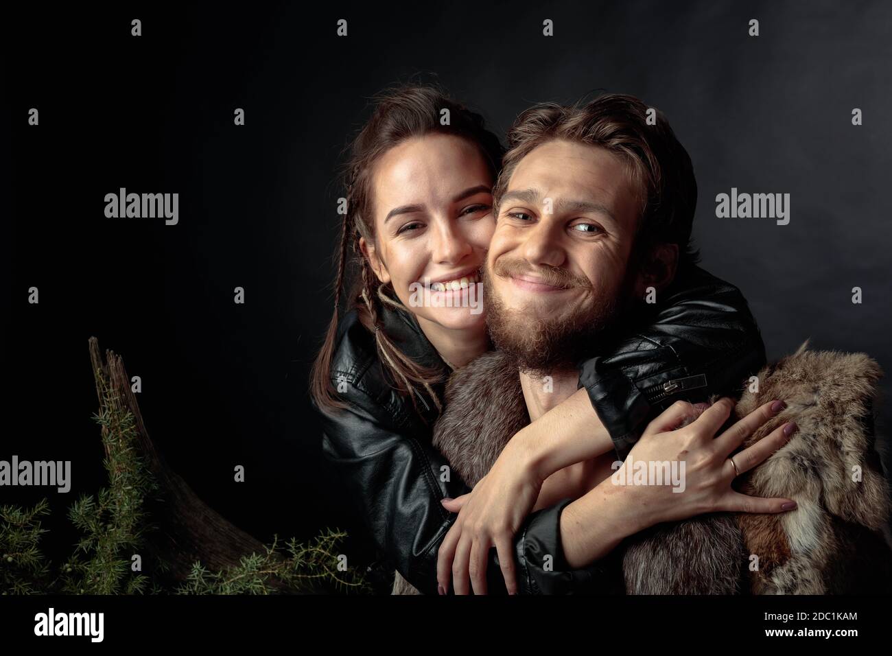 Bella giovane coppia sorridente. Una ragazza in una giacca nera in pelle abbraccia un uomo bearded in un gilet di pelliccia. Foto Stock