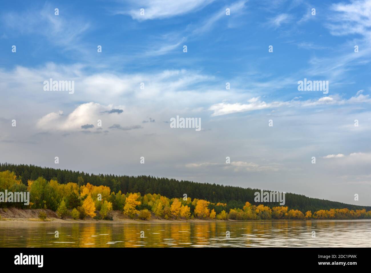 Paesaggio sul fiume, cielo blu con le nuvole, bordo della banca con foresta d'autunno Foto Stock