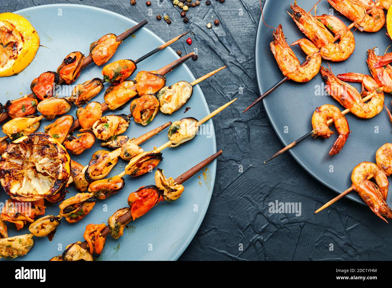 Deliziosi gamberi arrostiti e cozze su spiedini di legno Foto Stock