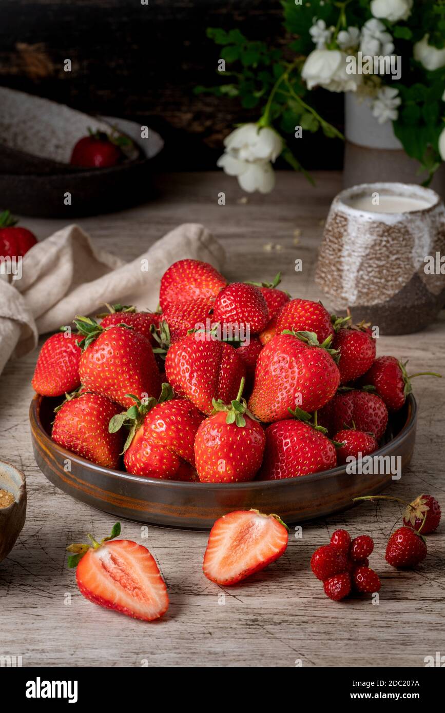 Foto scura di natura morta con fragola estiva, verticale Foto Stock