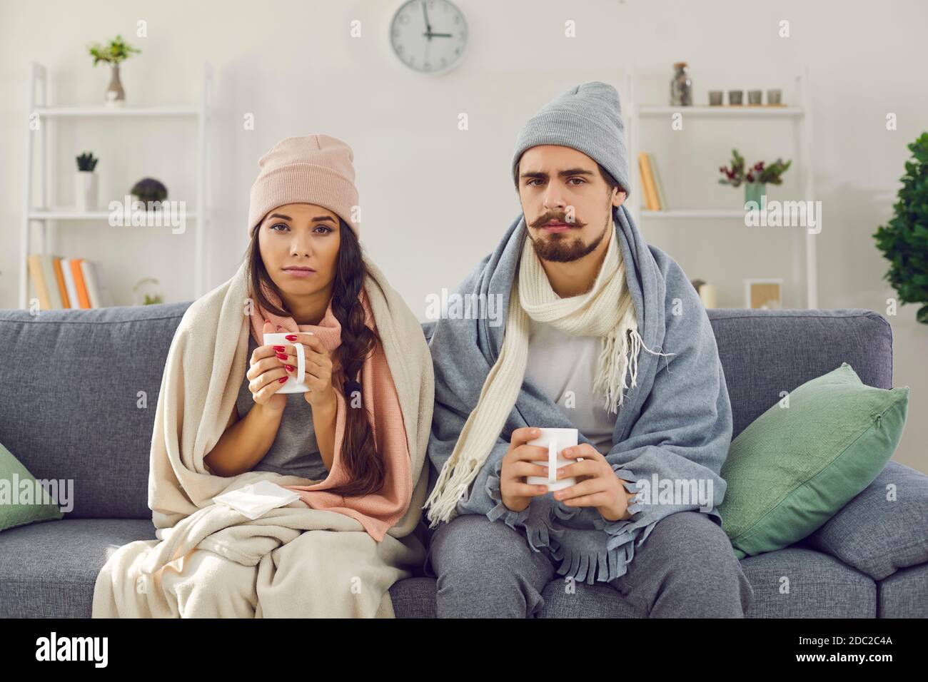 Turbata giovane coppia che ha problemi con il riscaldamento centrale o la sofferenza da freddo o influenza Foto Stock