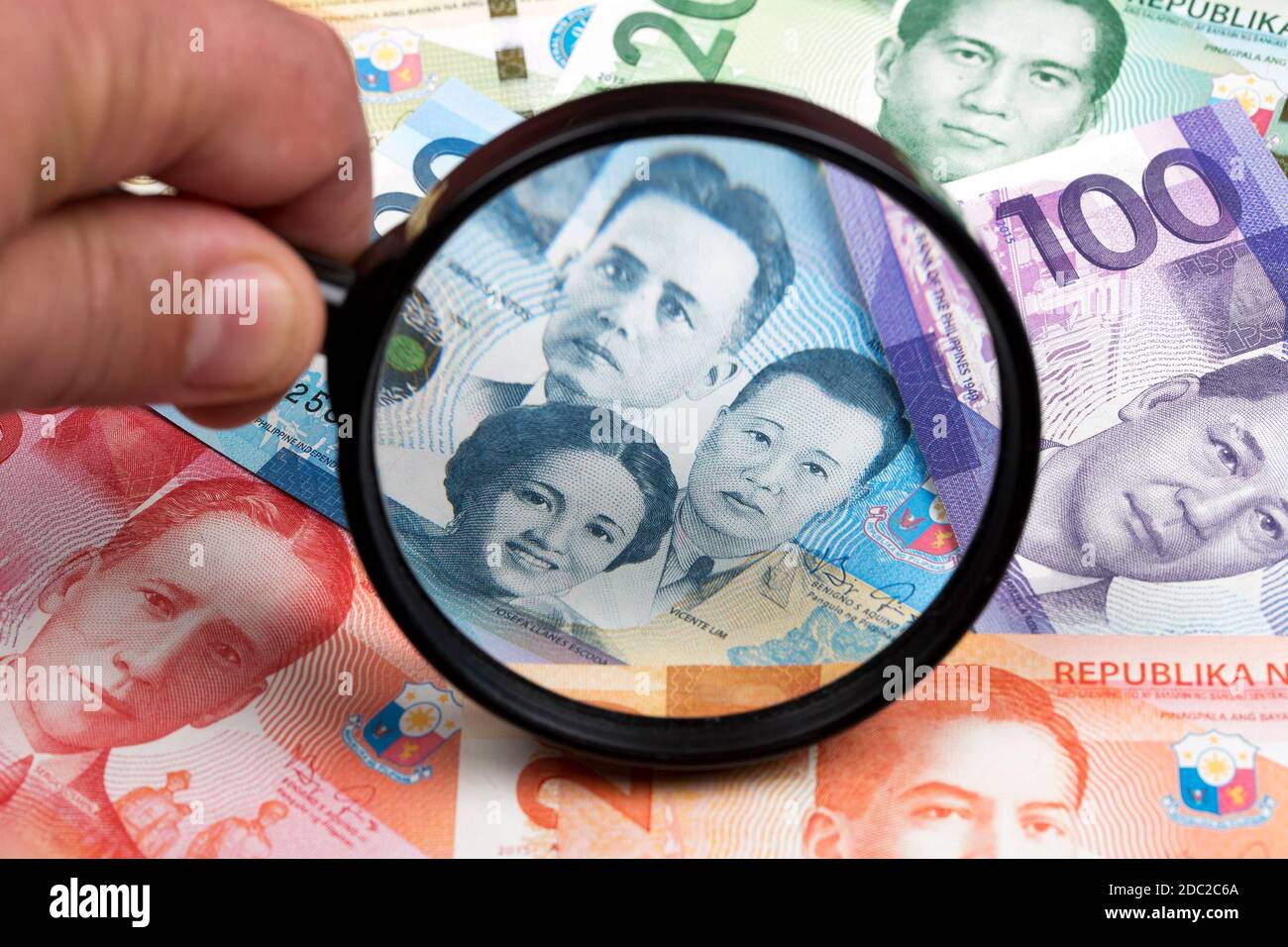 Peso filippino in una lente d'ingrandimento Foto Stock