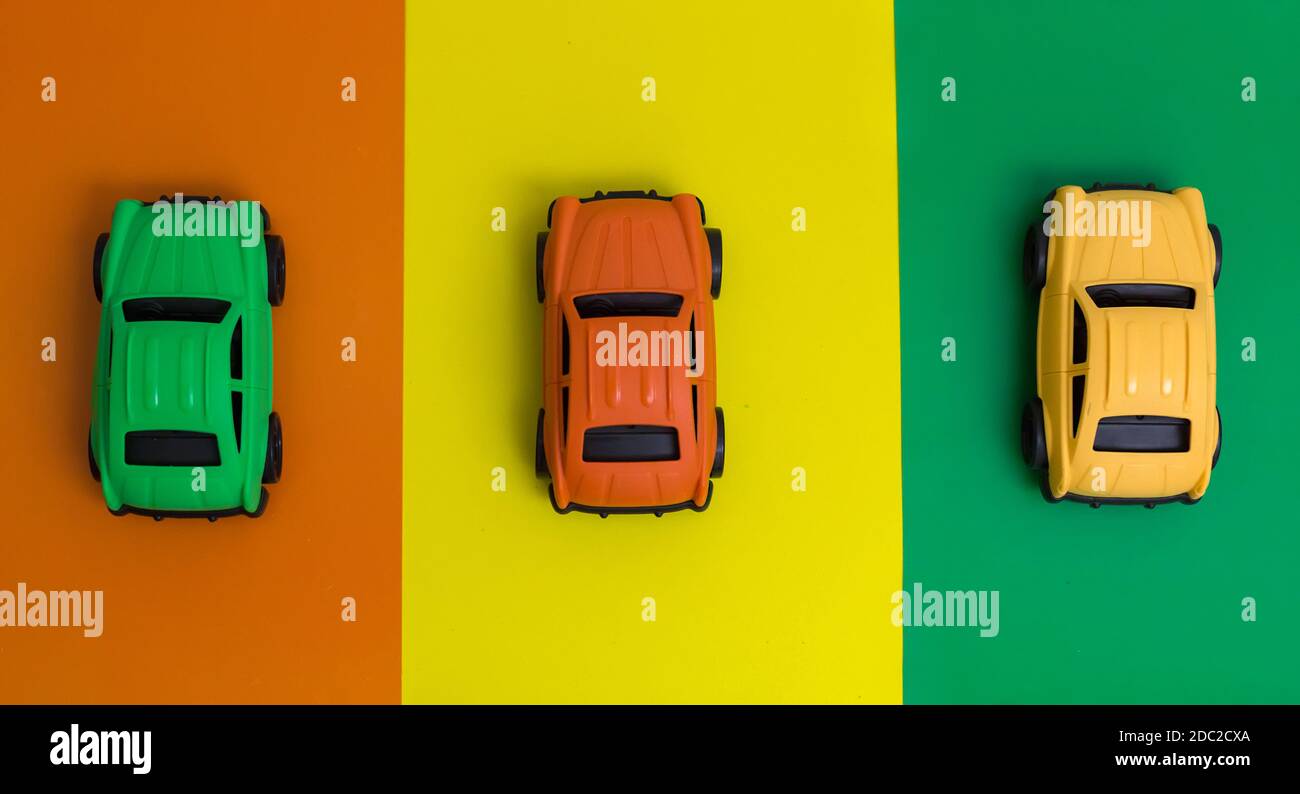 Tre coloratissime auto giocattolo realizzate in plastica riciclabile, consentono di risparmiare energia, non tossiche, riducono la produzione di gas serra Foto Stock