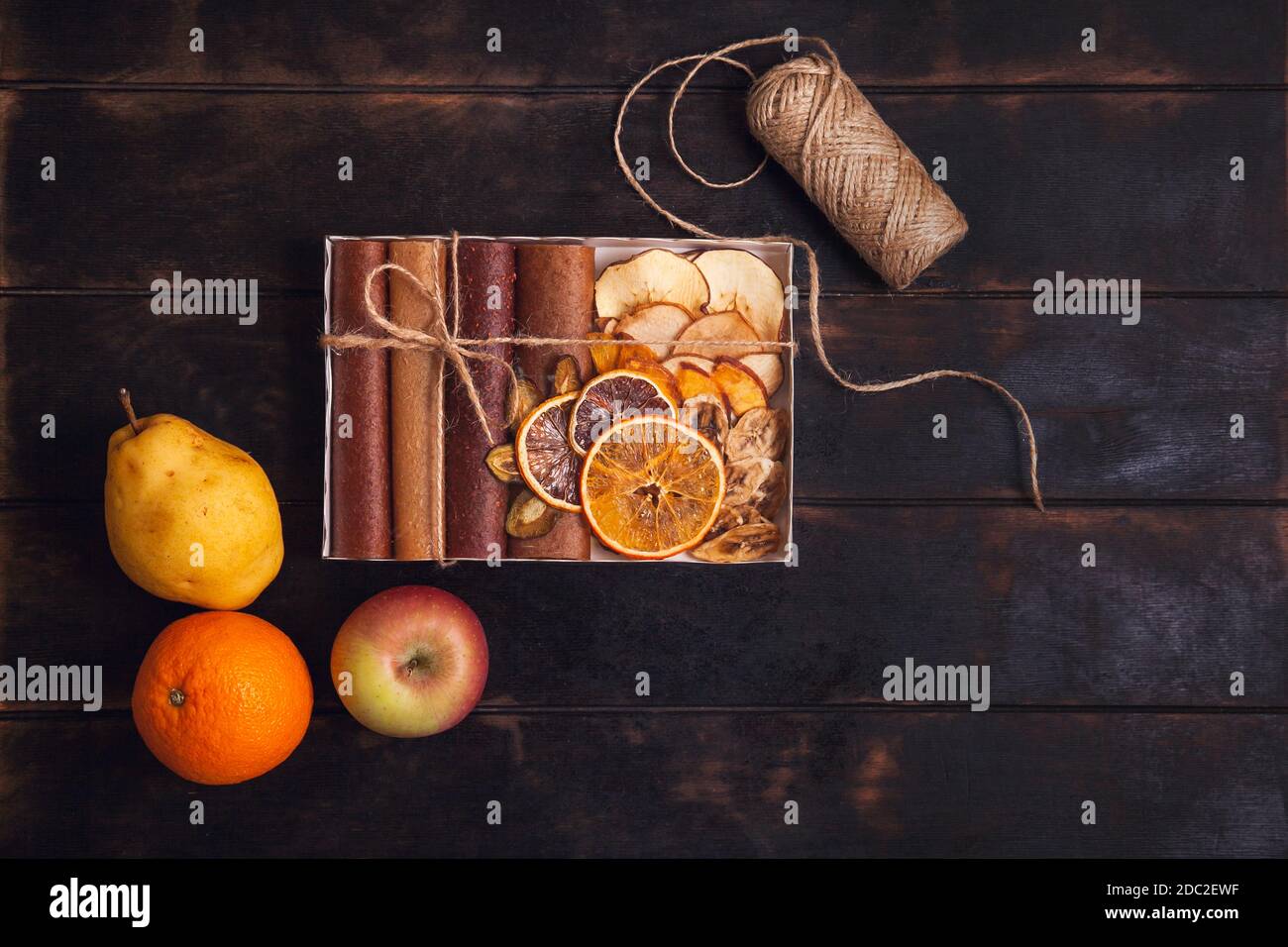 Scatole da imballaggio con spuntini di frutta dolce - pastiglie, frutta secca e frutta fresca - pera, mela, arancia. Foto Stock